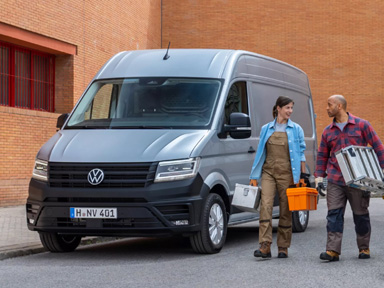 robotnicy stoją obok Volkswagena crafter